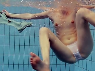 Slim redhead babe Nastya swimming in the pool all naked