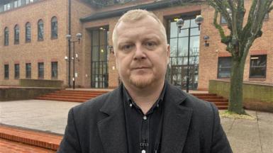 A man in black clothing stood in front of Derby Crown Court