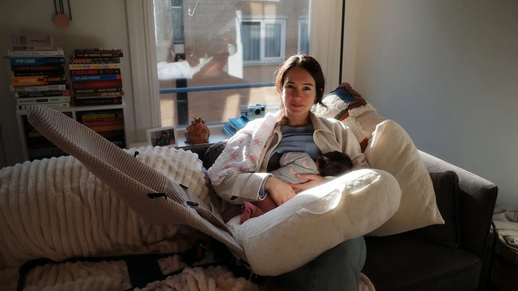 Kraamverzorgenden Sandra Leerves cuddles a newborn baby (Credit: Yenthe van Sasse van IJsselt)