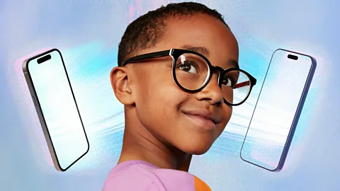 A child looks up with two bright phone screens on either side of their face (Credit: Serenity Strull/ Getty Images)