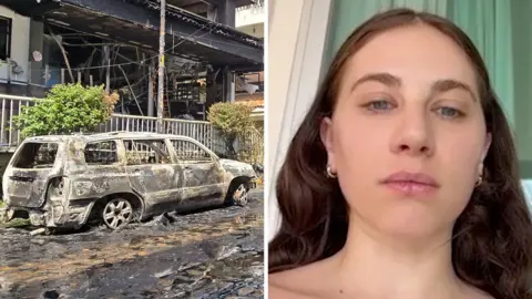 Splitscreen. Left, a burnt out car. Right, a woman speaks to camera.