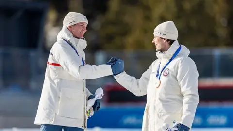 Sturla Holm Laegreid and Johan-Olav Botn shake hands on the podium