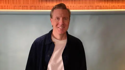 Patrick smiling in the studio as a guest on Ready to Talk