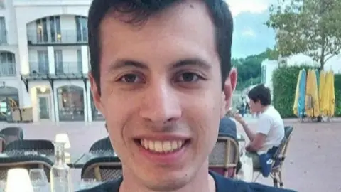 A  young man called Quentin Deranque sits outside