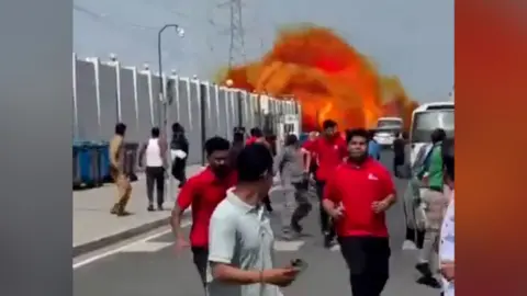 People running away from large fireball in background