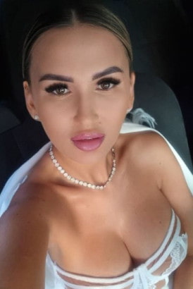 Busty blonde girl in a black cat-suit taking a selfie