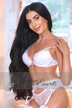 A hot girl with lond black hair smiling sweetly