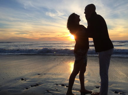 A boyfriend and girlfriend on a beach at sundown