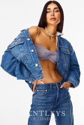 Stylish brunette in a jean jacket falling off her shoulders